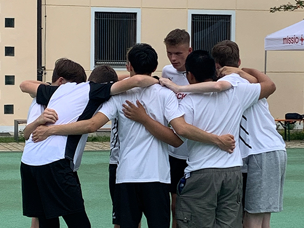 Der Kapitän einer Mannschaft schwört die Mannschaft vor dem Finale beim missio Unity-Cup ein. Die Mitglieder der Mannschaft stehen im Kreis und legen sich die Arme um die Schultern.