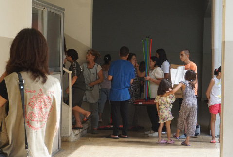 Geflüchtete Menschen stehen in einer Schlange in einer Schule in Beirut an, die Hilfen anbietet.